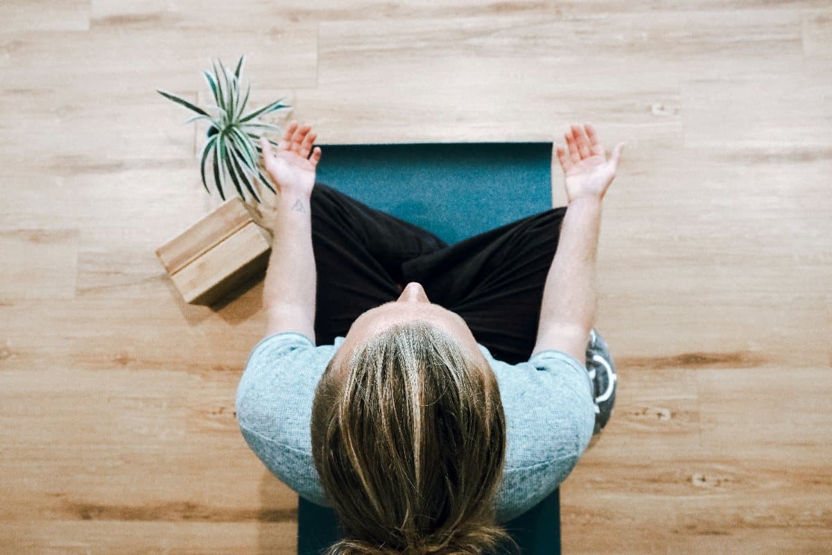Person seated cross-legged on a yoga mat, seen from above